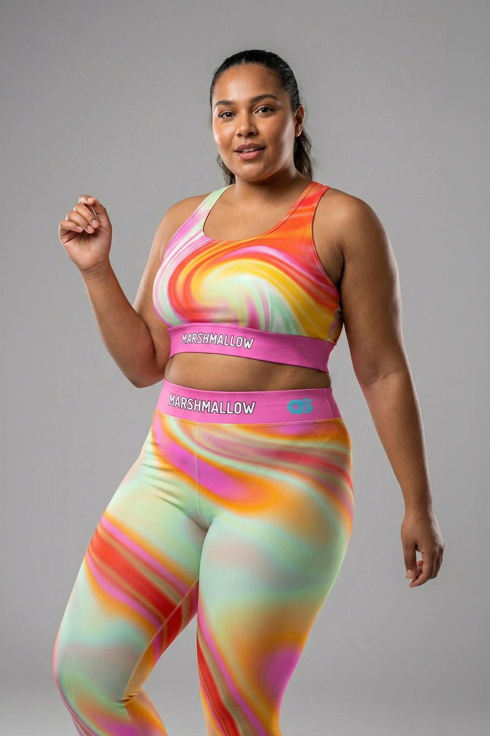 Front view of pastel tie-dye sports bra in peach, yellow, mint, and pink, featuring 'MARSHMALLOW' printed on the bubblegum pink waistband.