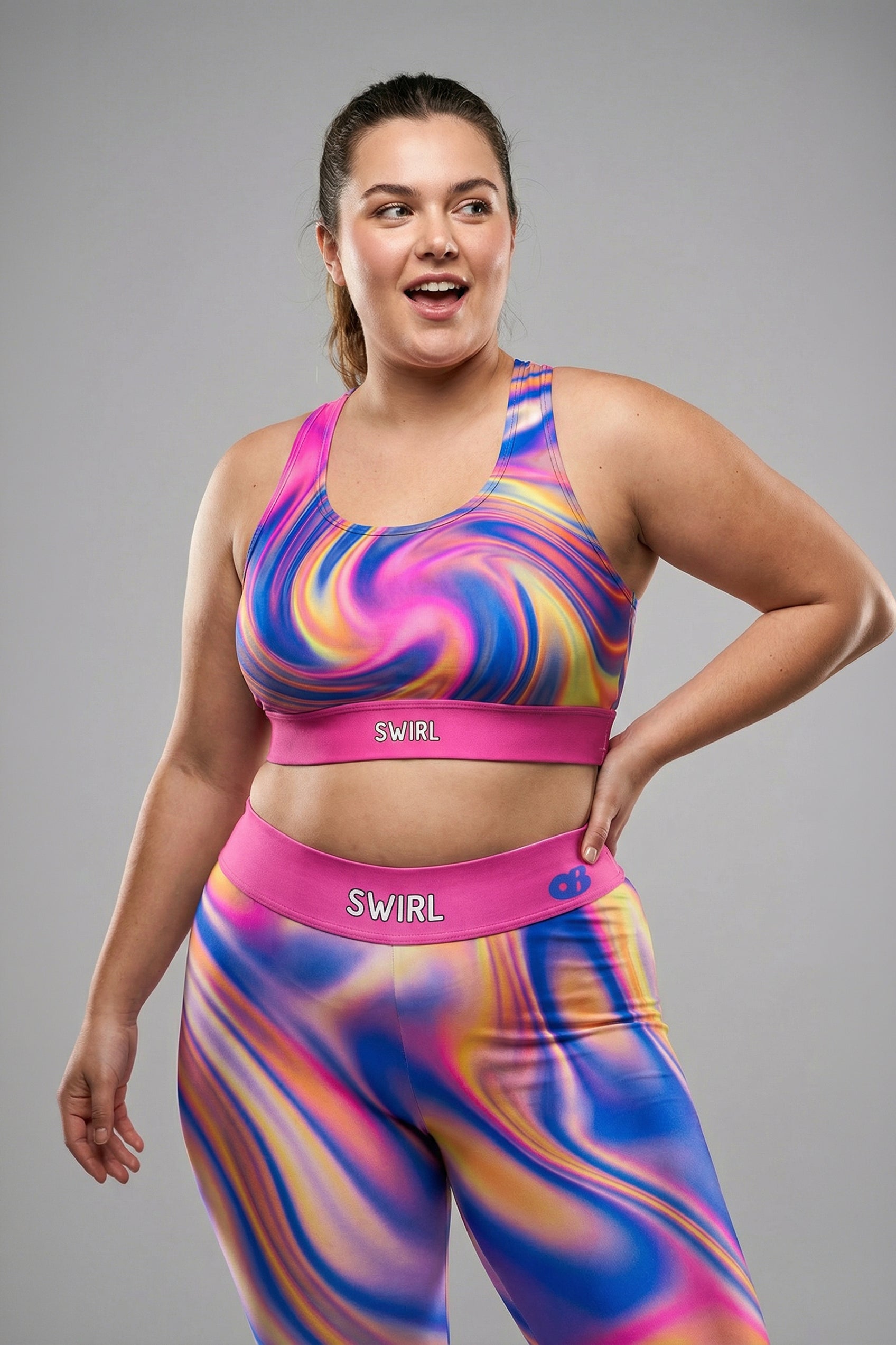 Front view of dark tie-dye sports bra in midnight blue, purple, and black swirls, featuring 'MYSTIC' printed on the solid black waistband.