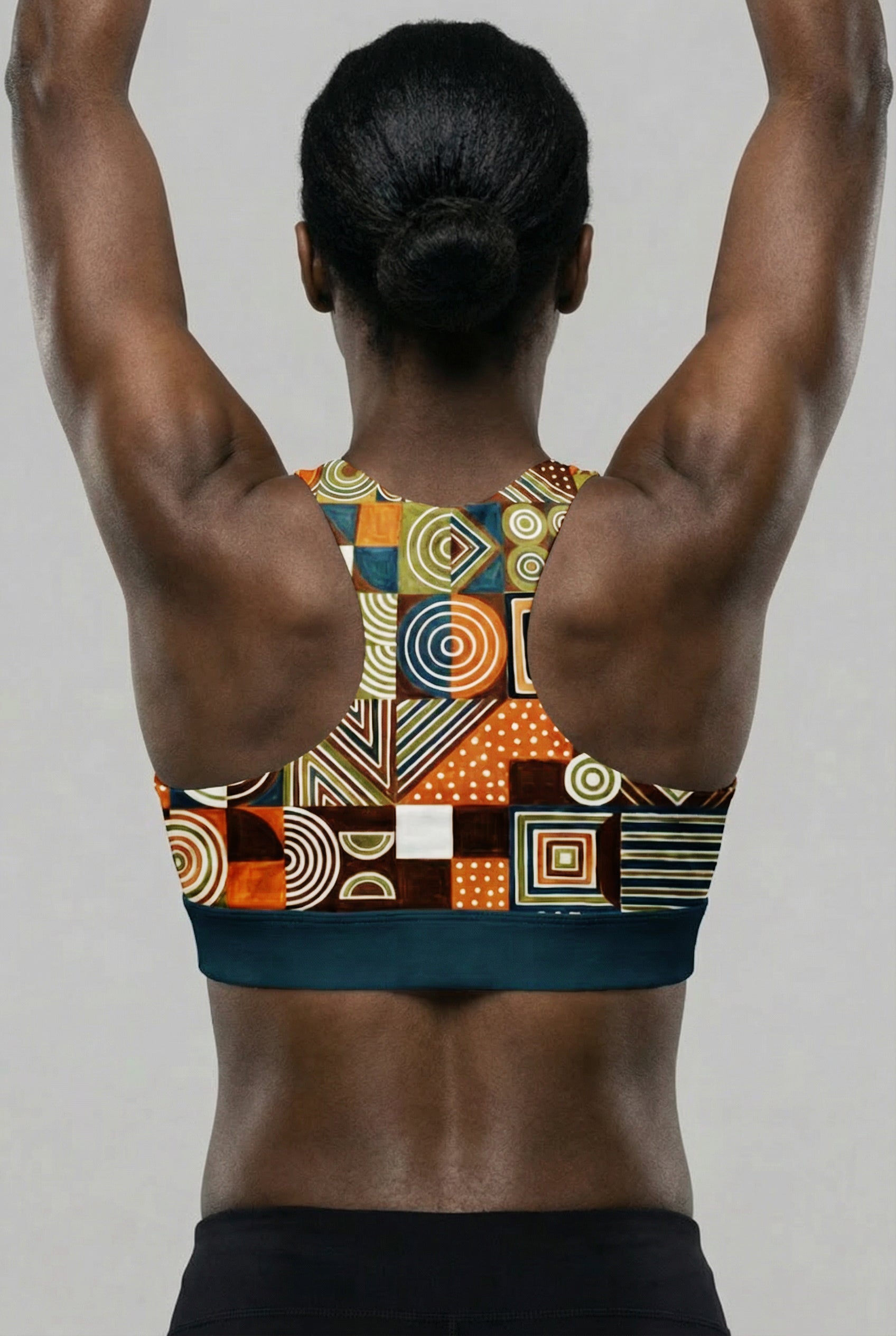 Person wearing a colorful geometric-patterned sports bra against a plain background