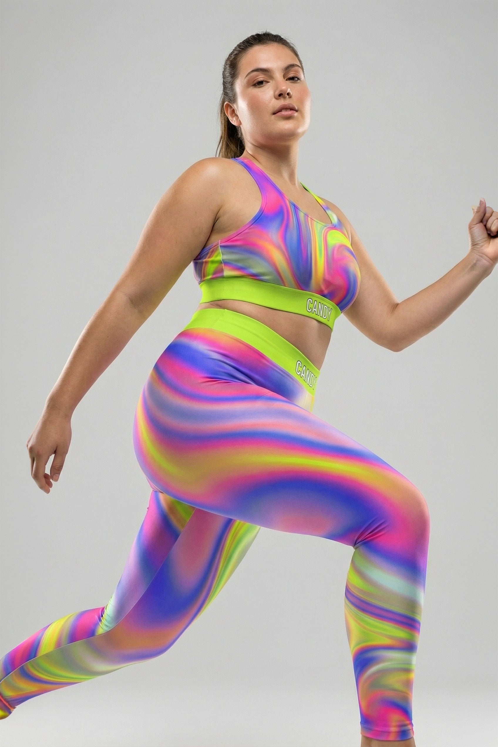 Front view of neon tie-dye sports bra in lime green, pink, and purple, featuring 'CANDY' printed on the bright neon lime waistband.