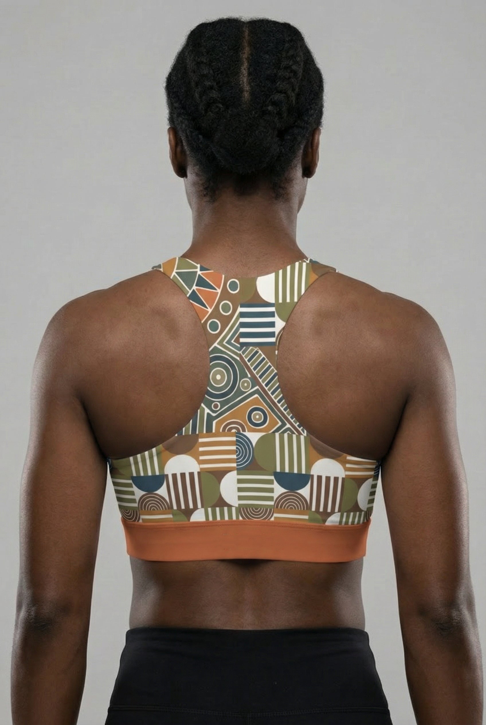 Person wearing a patterned sports bra with a geometric design on a plain background