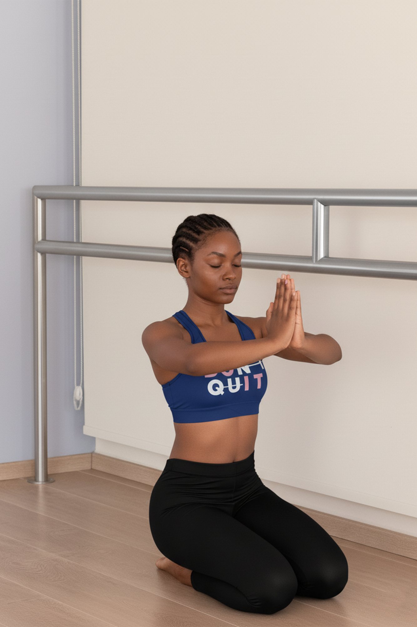 Woman in a yoga pose with 'Don't Quit' sports bra in a room with a ballet barre.