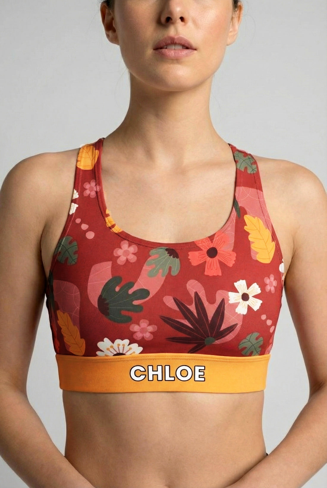 Deep red sport bra with vintage floral print and custom name 'CHLOE' on mustard yellow waistband.