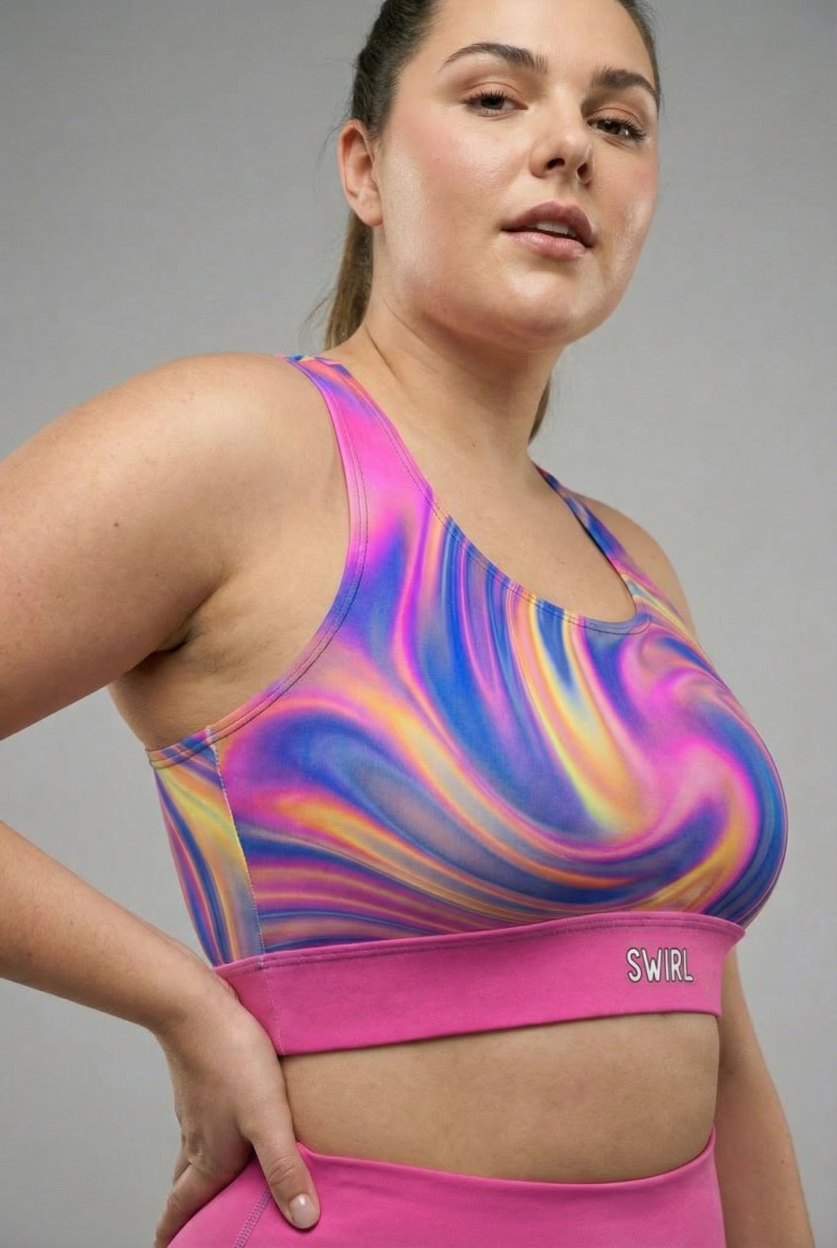 Front view of dark tie-dye sports bra in midnight blue, purple, and black swirls, featuring 'MYSTIC' printed on the solid black waistband.