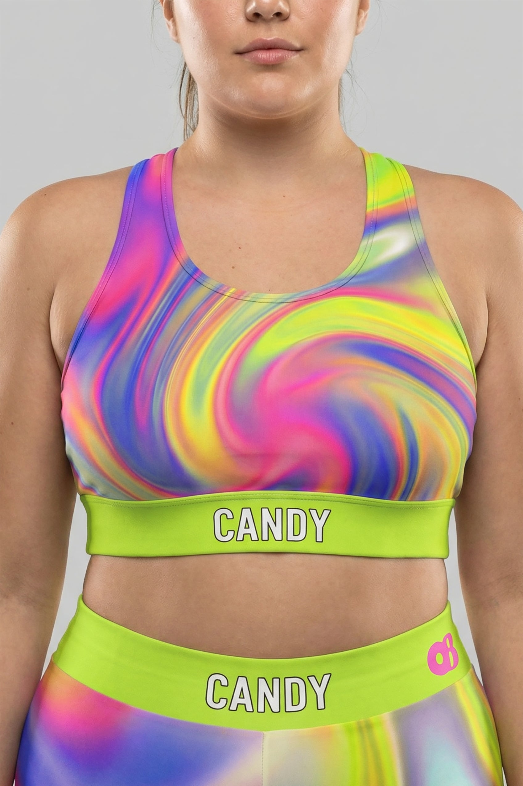 Front view of neon tie-dye sports bra in lime green, pink, and purple, featuring 'CANDY' printed on the bright neon lime waistband.