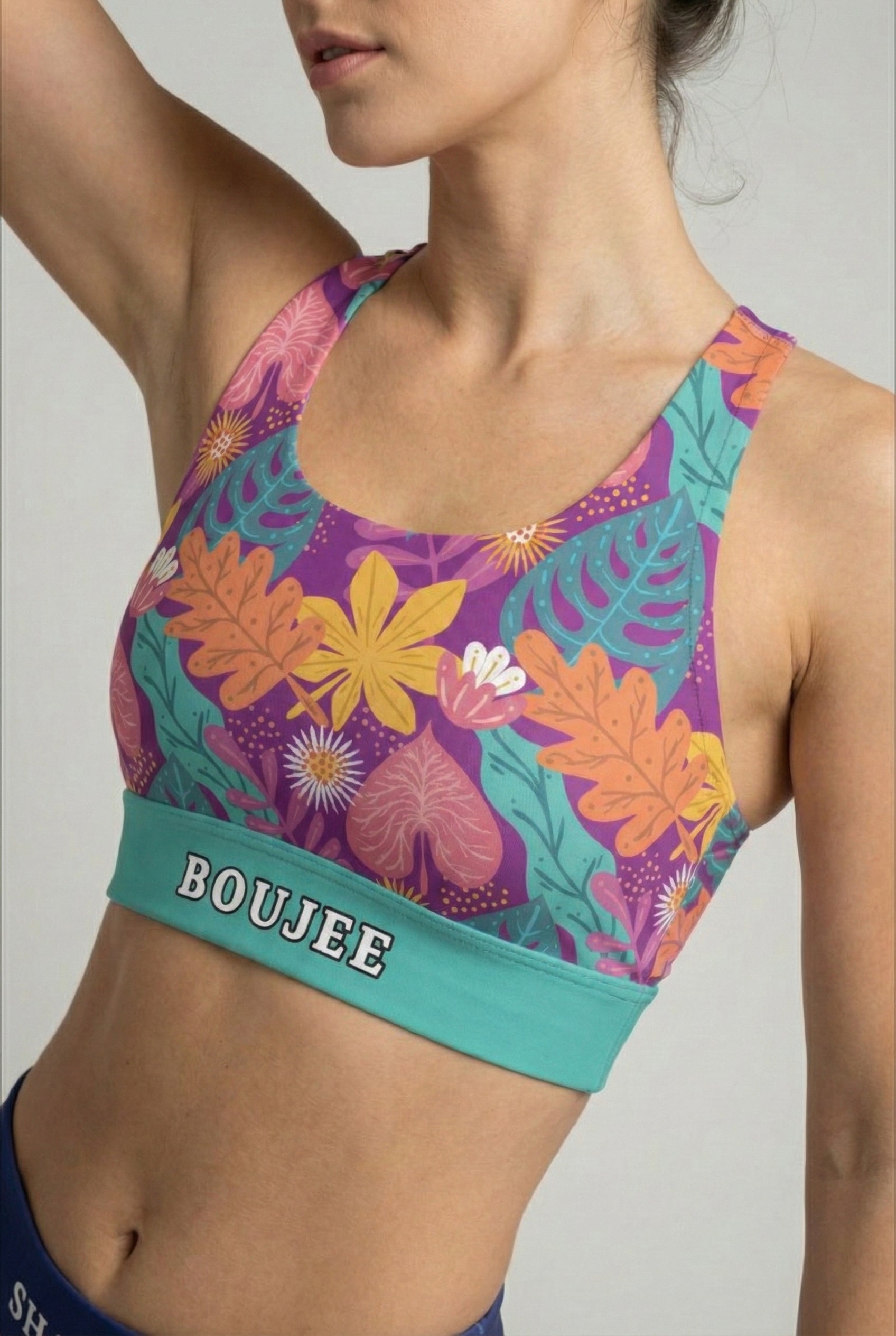 Purple and teal sport bra with stylized tropical leaf print and custom text 'BOUJEE' on waistband.