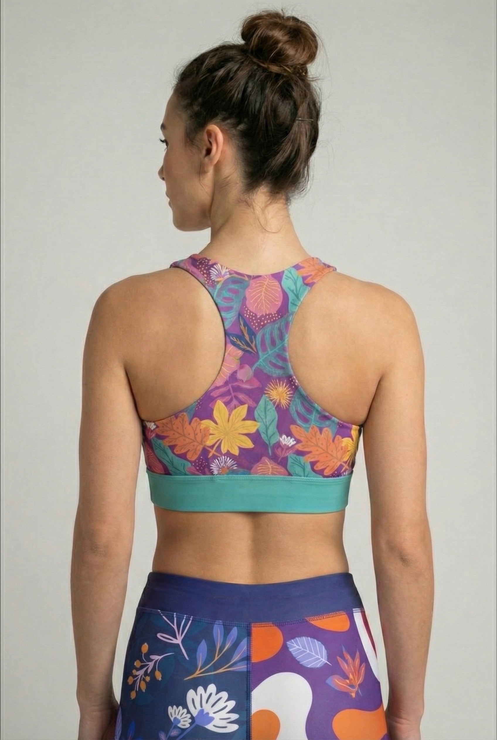 oman wearing personalized vibrant tropical sport bra with teal trim.
