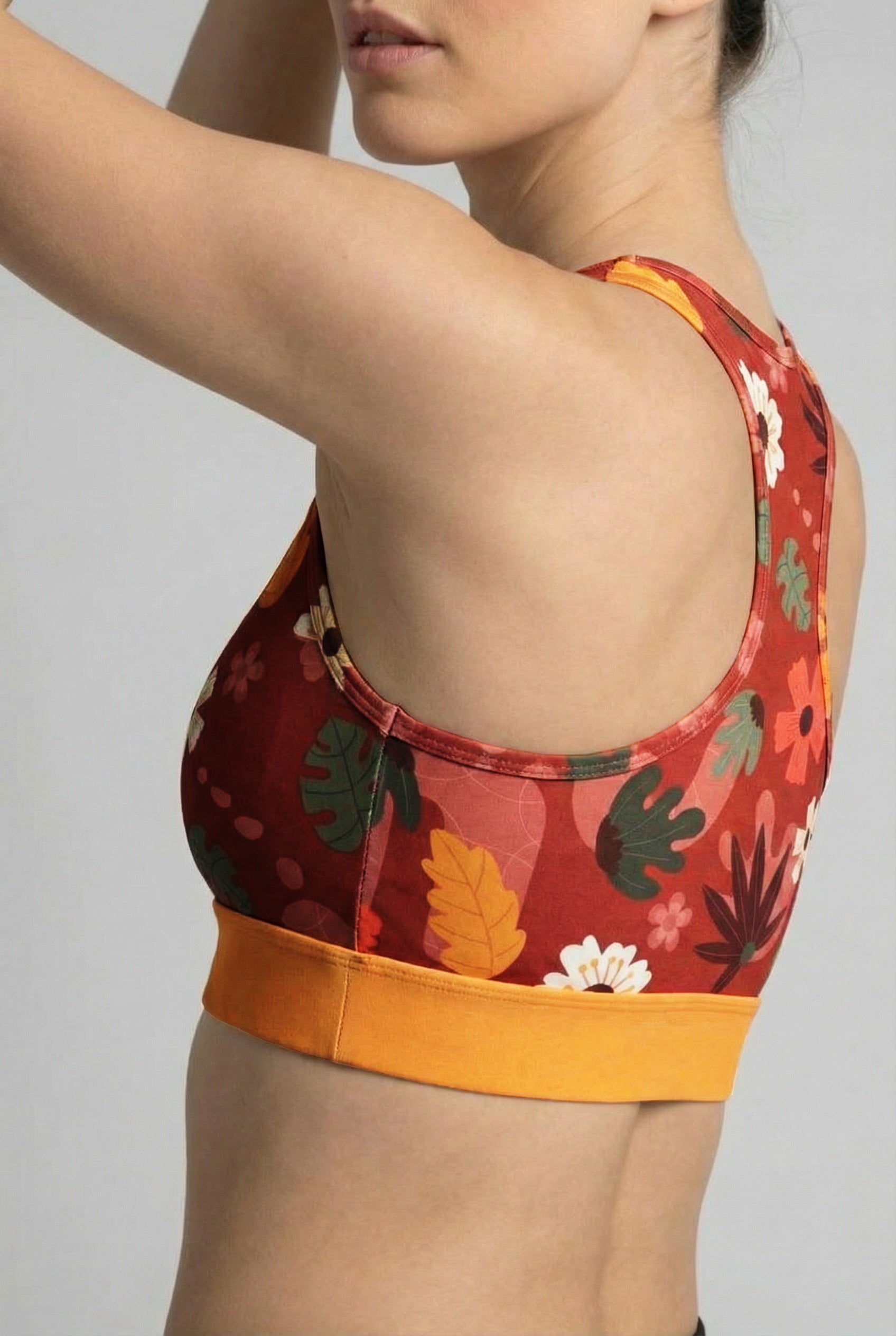 Retro botanical pattern with white flowers and stylized leaves on burgundy activewear.