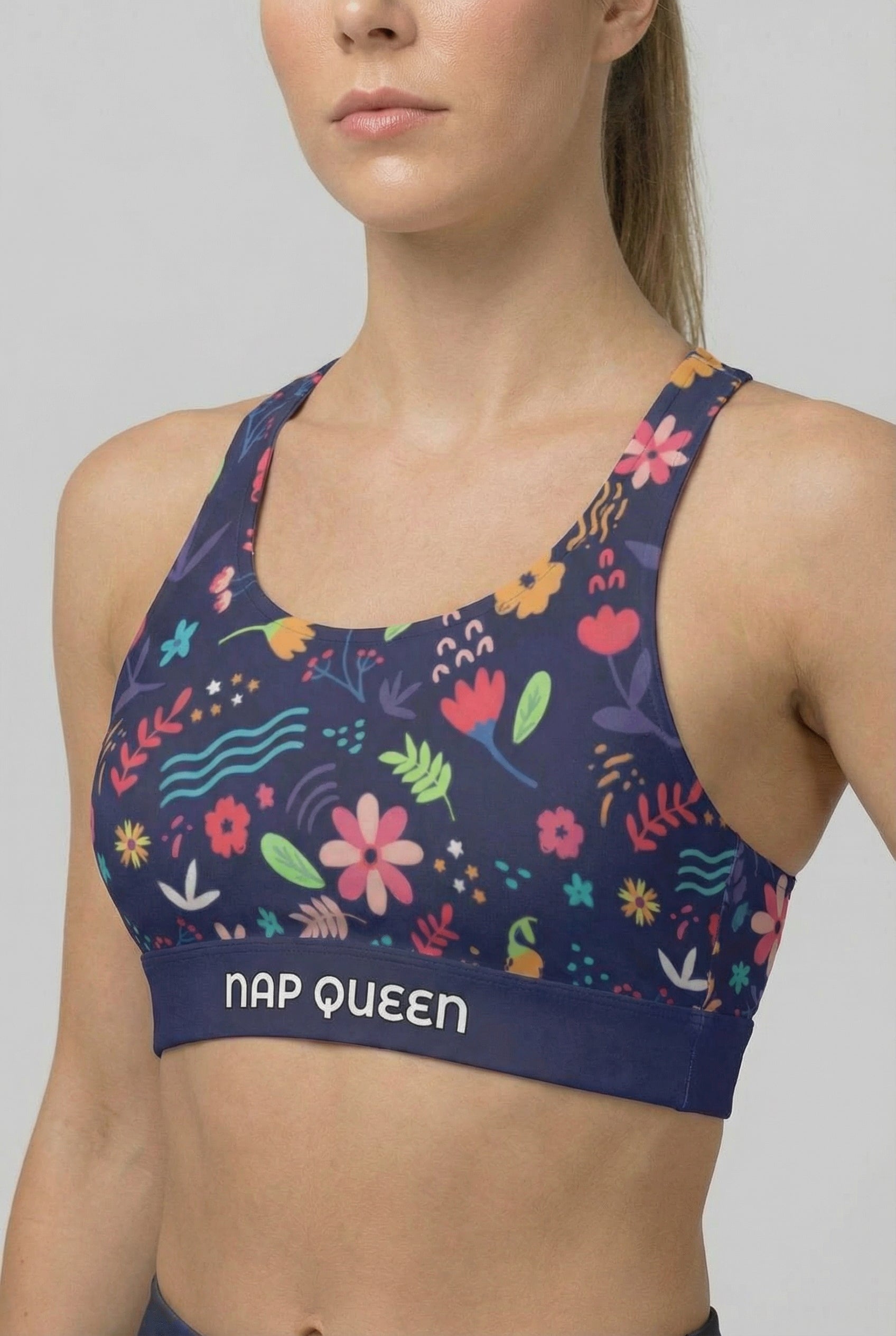 Navy sport bra with colorful hand-drawn floral print and custom text 'NAP QUEEN' on waistband