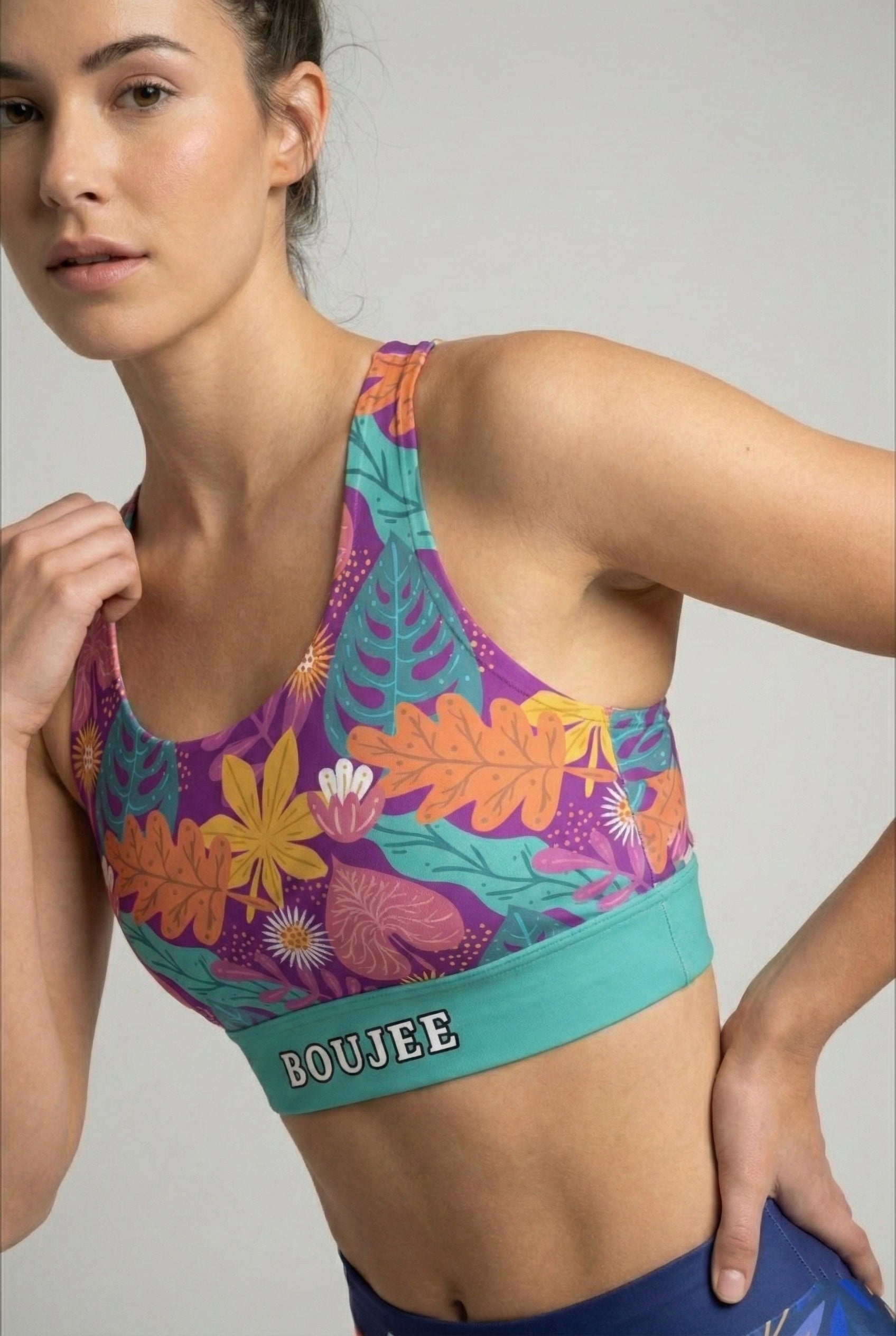Close up of colorful foliage pattern with orange and pink leaves on purple activewear.