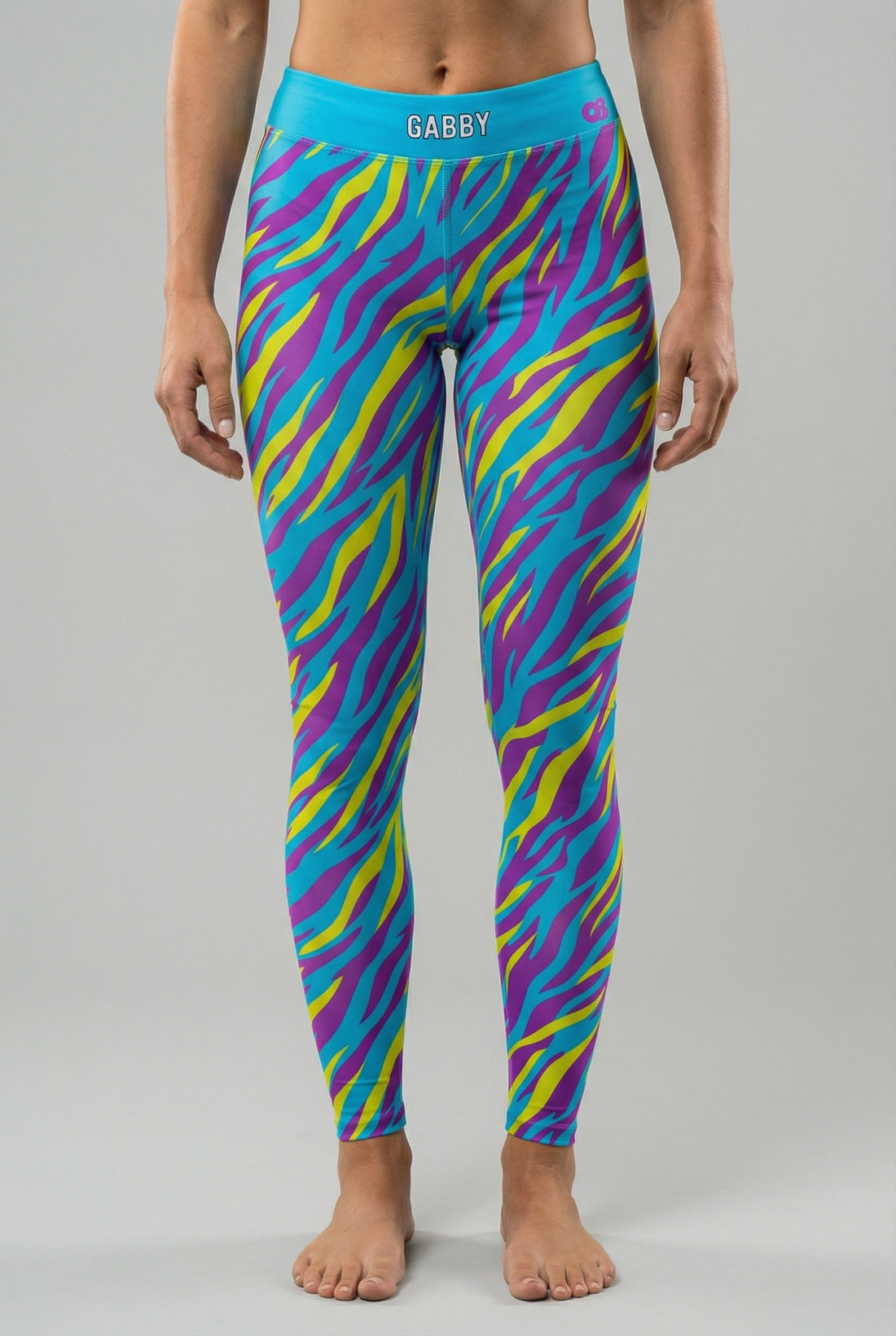Front view of high-waisted leggings featuring bright cyan, electric yellow, and purple tiger stripes, with 'GABBY' printed on the solid cyan blue waistband