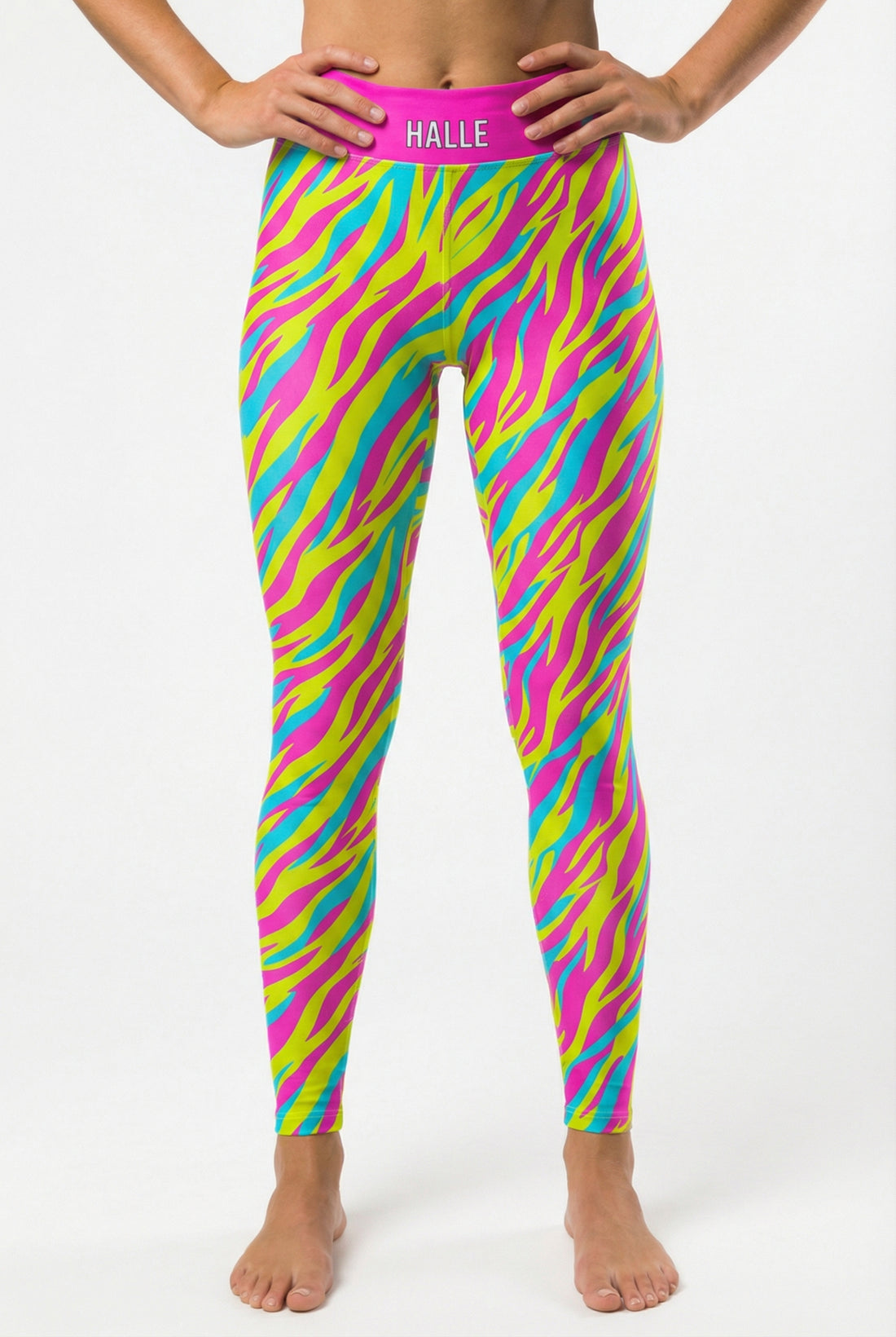 Front view of high-waisted leggings featuring neon pink, yellow, and cyan tiger stripes, with 'HALLE' printed on the solid hot pink waistband.