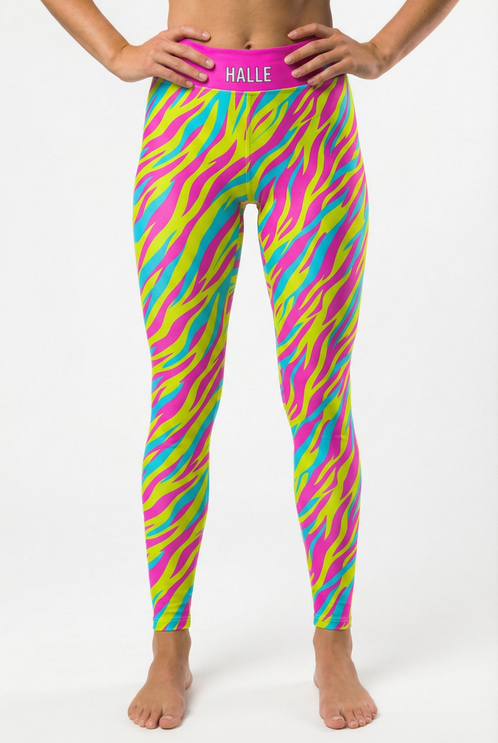 Front view of high-waisted leggings featuring neon pink, yellow, and cyan tiger stripes, with 'HALLE' printed on the solid hot pink waistband.