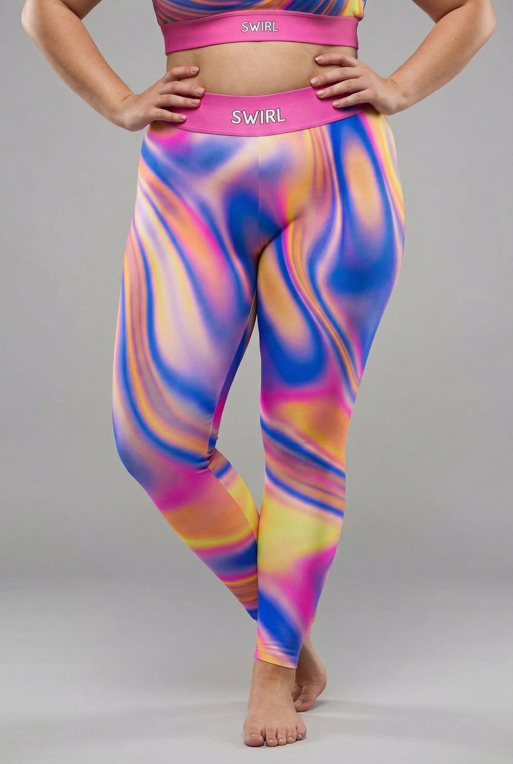 Front view of vibrant tie-dye swirl leggings in royal blue, magenta, yellow, and orange, featuring 'SWIRL' printed on the solid magenta waistband.
