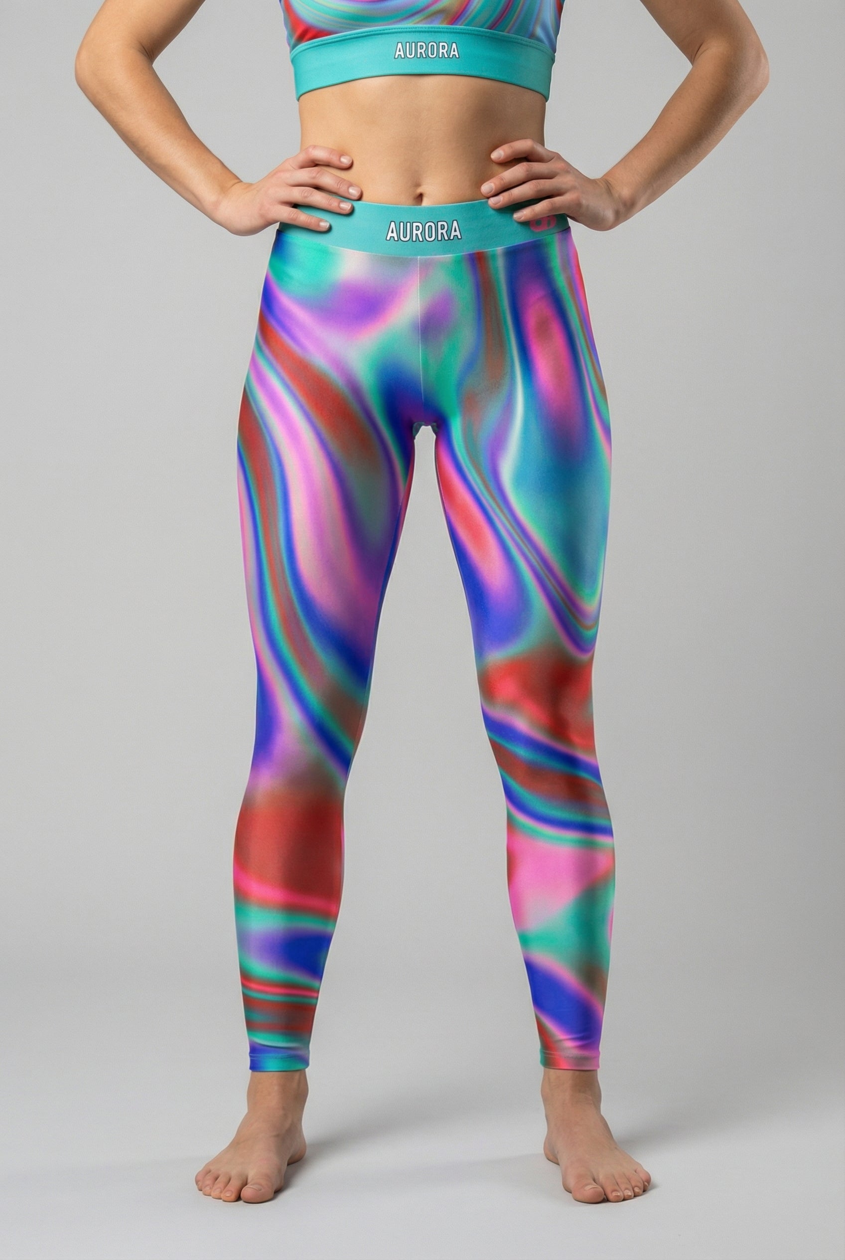 Front view of multi-color tie-dye swirl leggings in teal, purple, and green, featuring 'AURORA' printed on the bright teal waistband.