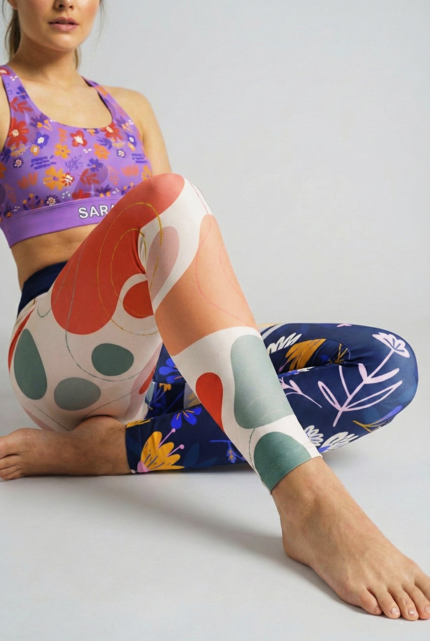 Close up of terracotta and sage green abstract blobs contrasting with dark blue wildflower print.