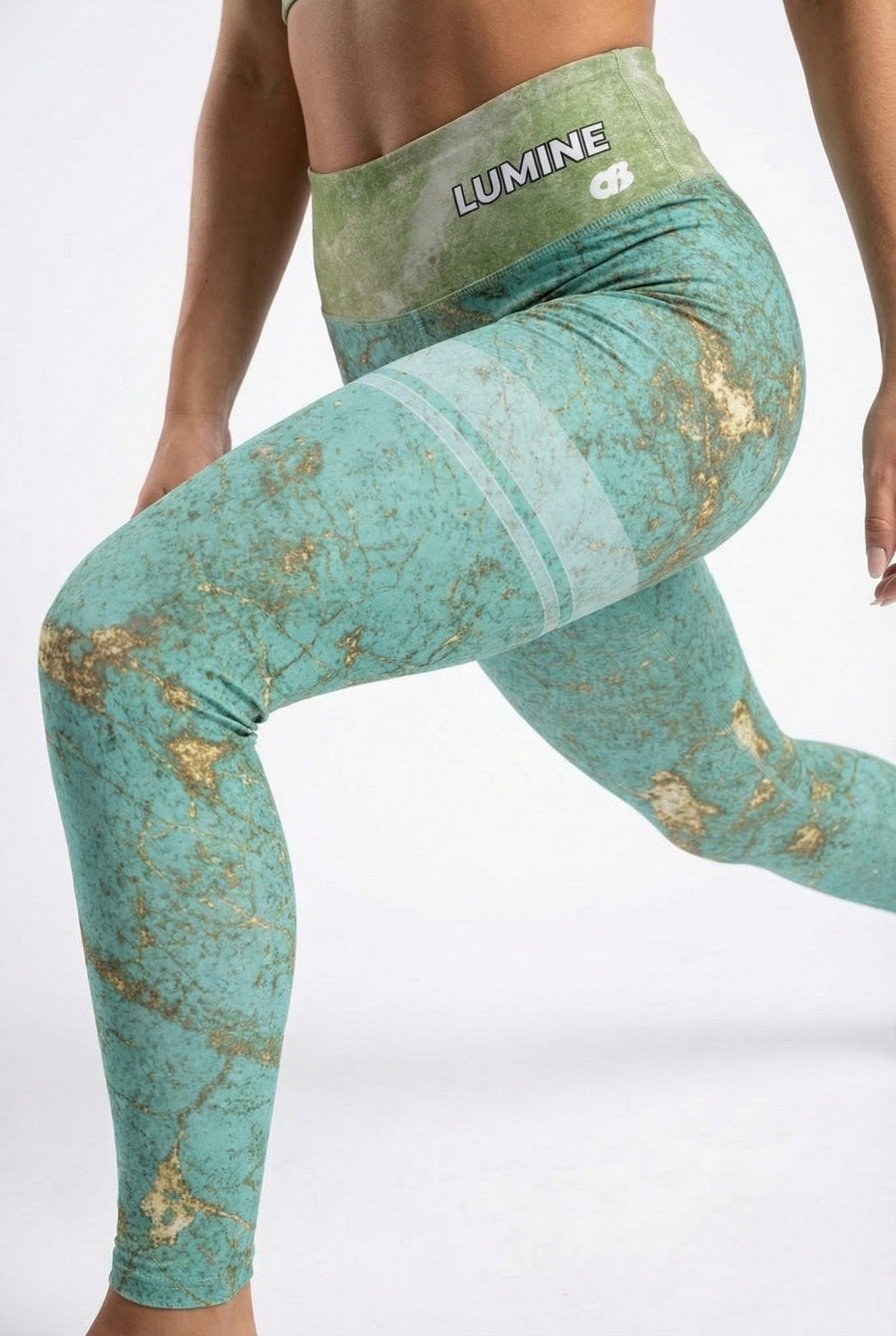 Teal leggings with gold accents and 'Lumine' branding on a white background