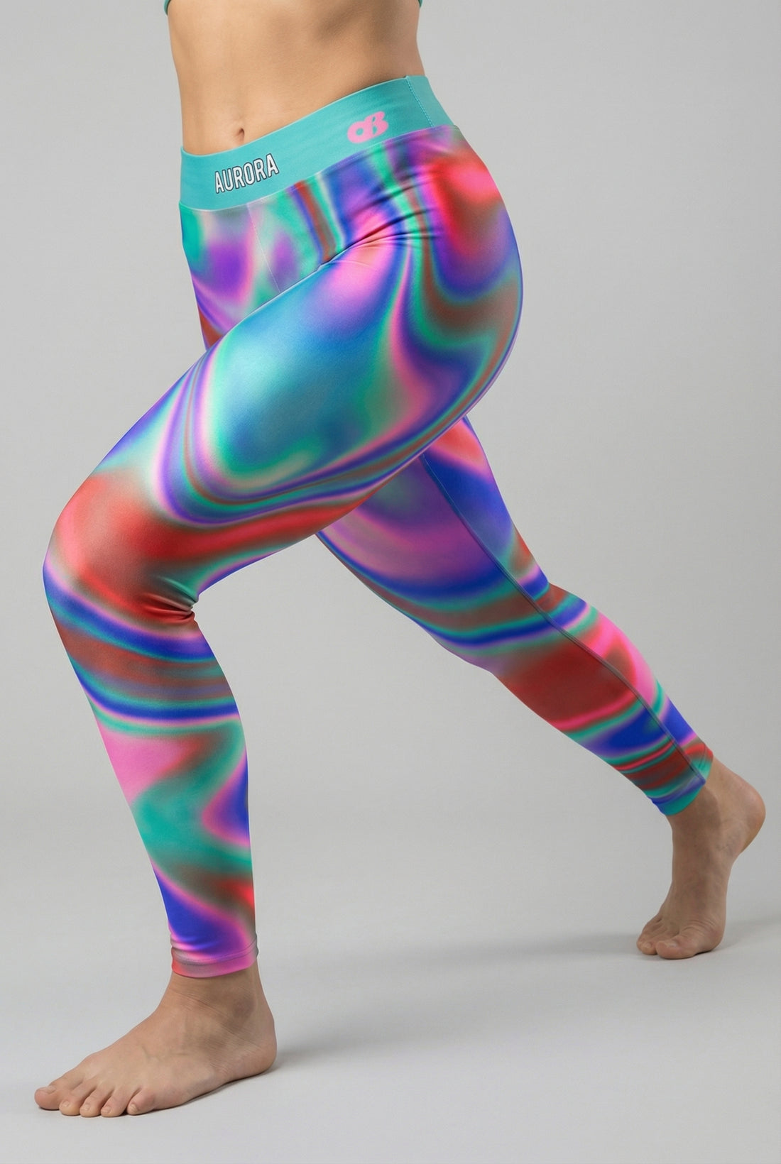 Front view of multi-color tie-dye swirl leggings in teal, purple, and green, featuring 'AURORA' printed on the bright teal waistband.