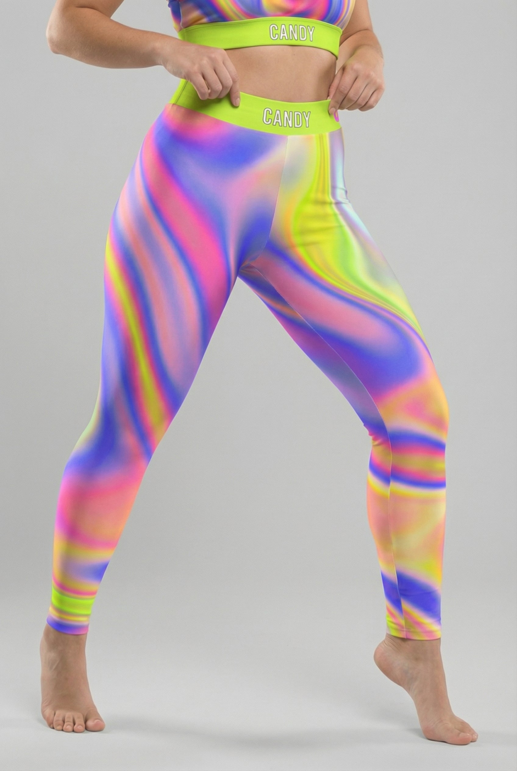 Front view of neon tie-dye swirl leggings in lime green, pink, and purple, featuring 'CANDY' printed on the bright neon lime waistband.
