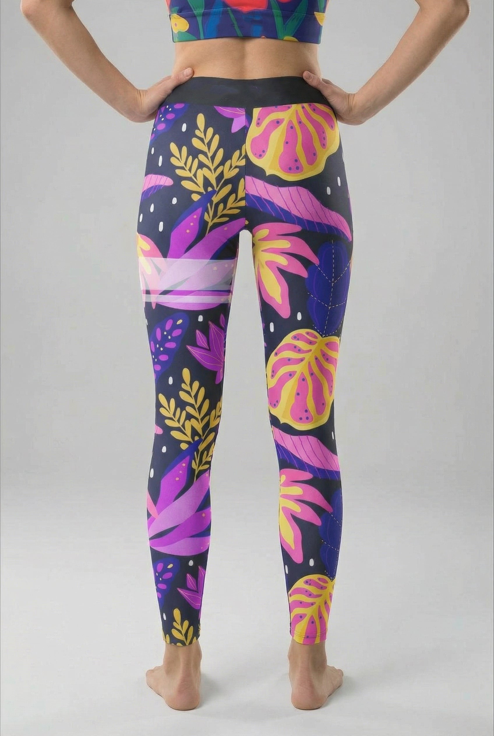 Colorful tropical leaf pattern leggings on a plain background
