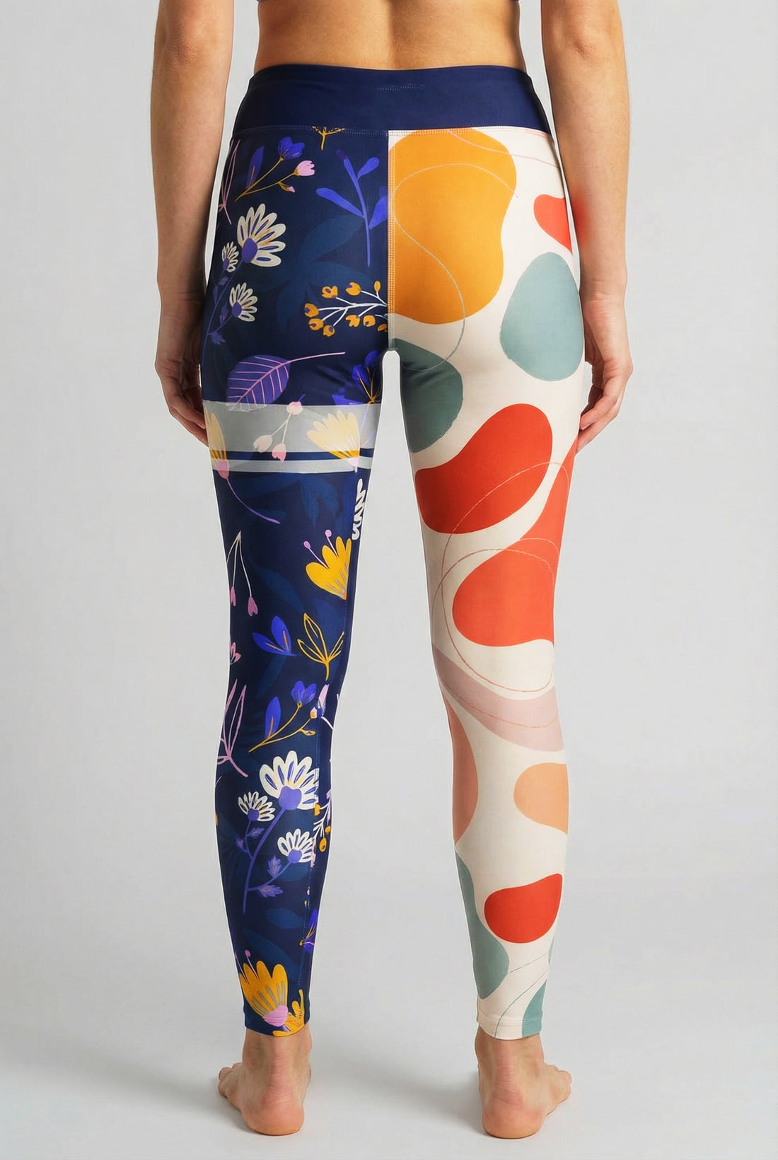 Split-leg leggings with beige abstract shapes on left leg and navy floral print on right leg, custom text 'LEXI' on waistband.