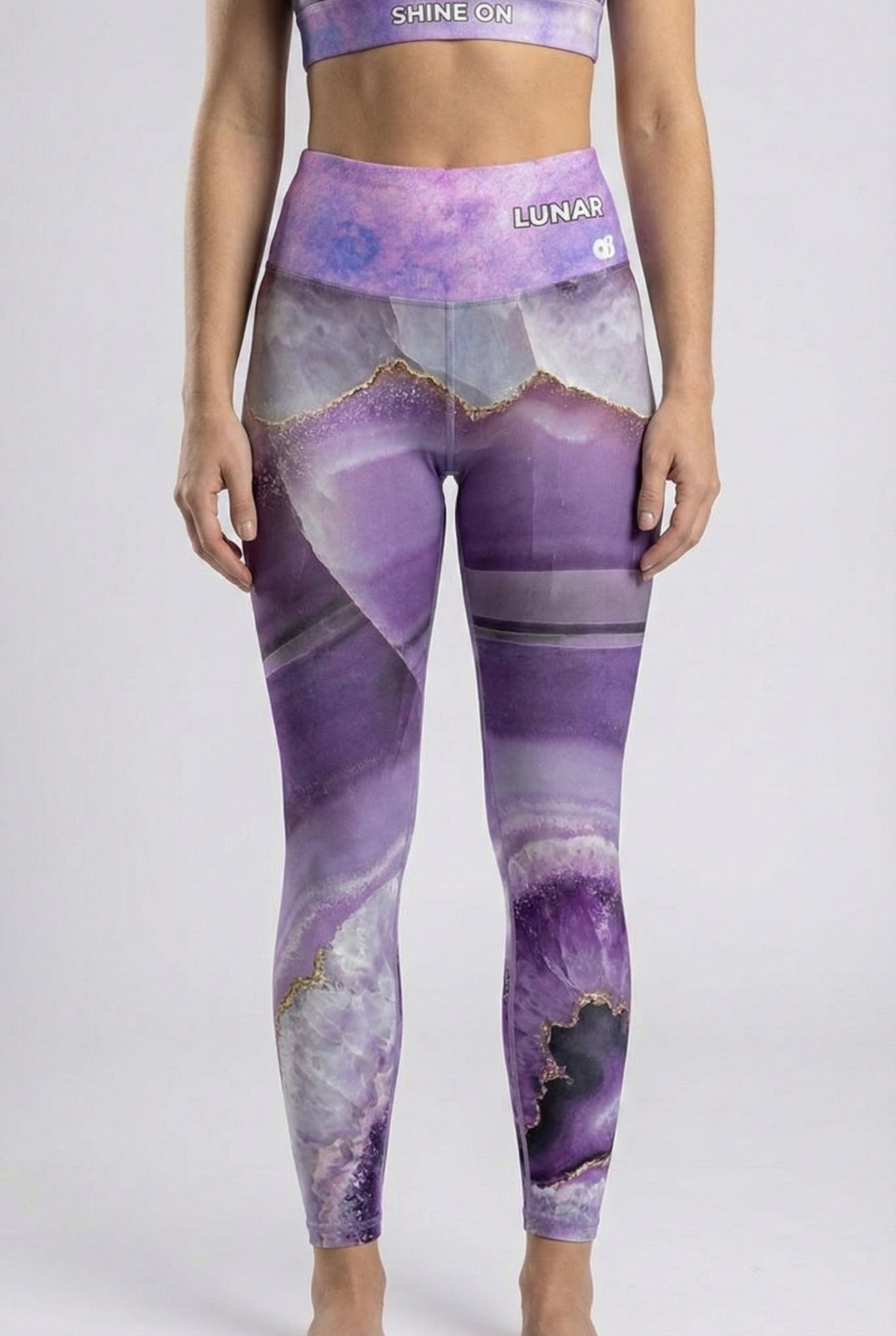 Person wearing purple and gray patterned leggings with a white background