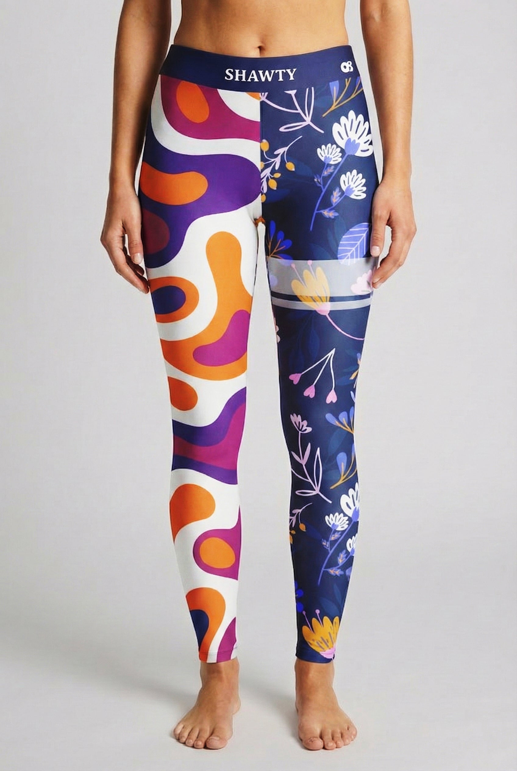 Split-leg leggings featuring orange/purple swirls on one side and navy floral print on the other, with custom text 'SHAWTY' on waistband.