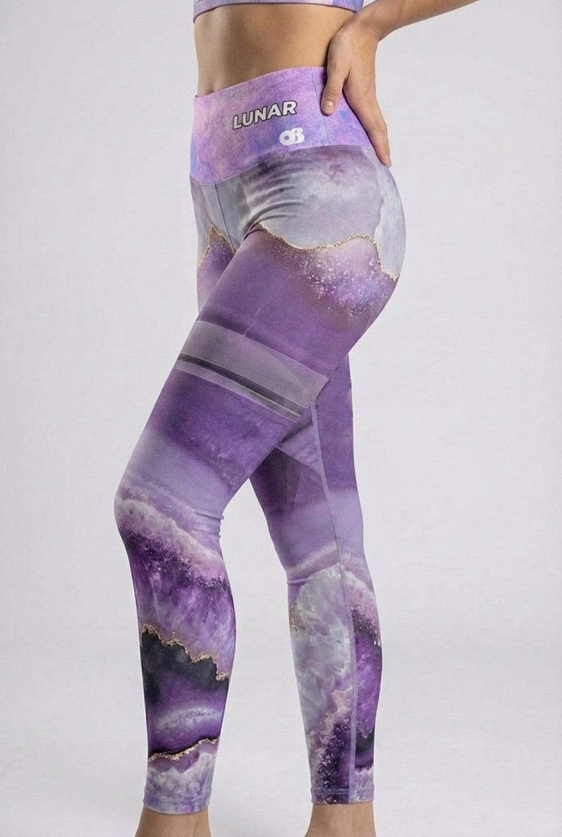 Person wearing purple and gray patterned leggings with a white background